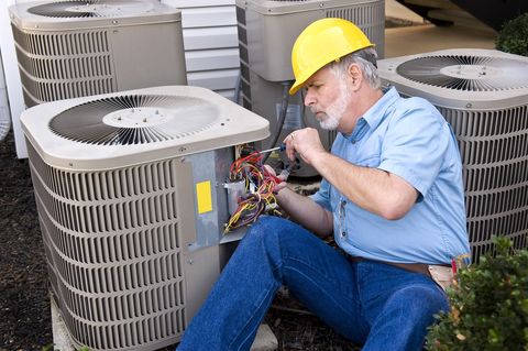 A Lakes Heating and Air Conditioning technician working on an HVAC unit
