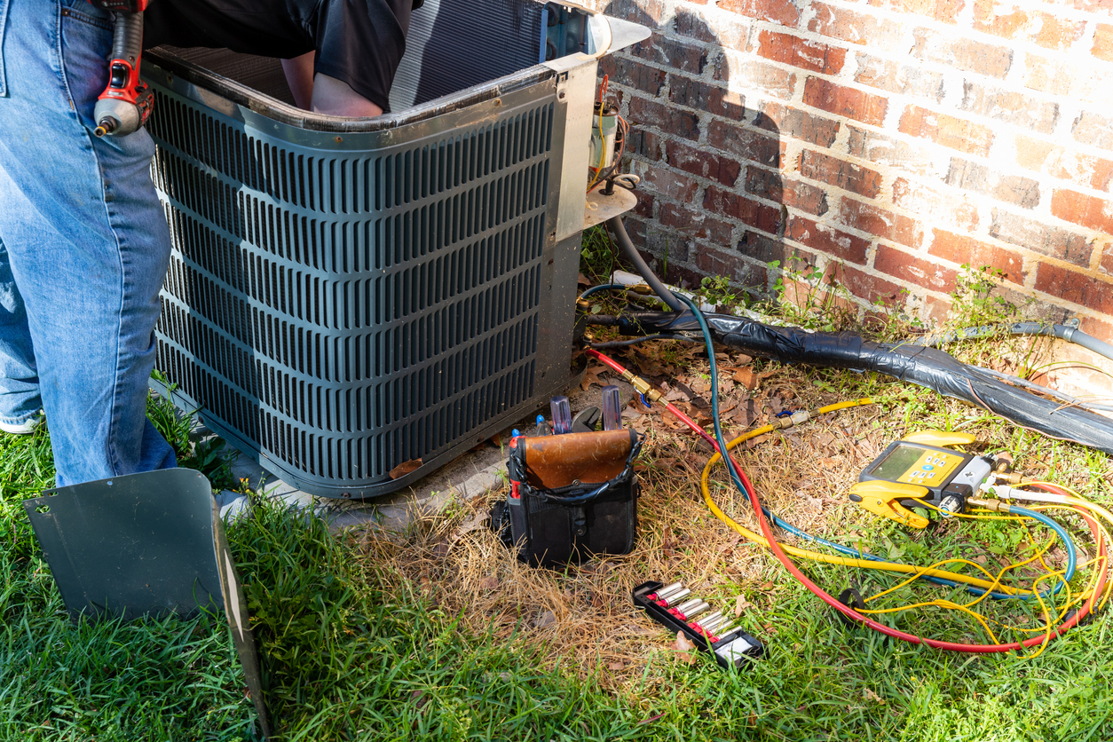 AC technician performing a tune-up service on a residential system