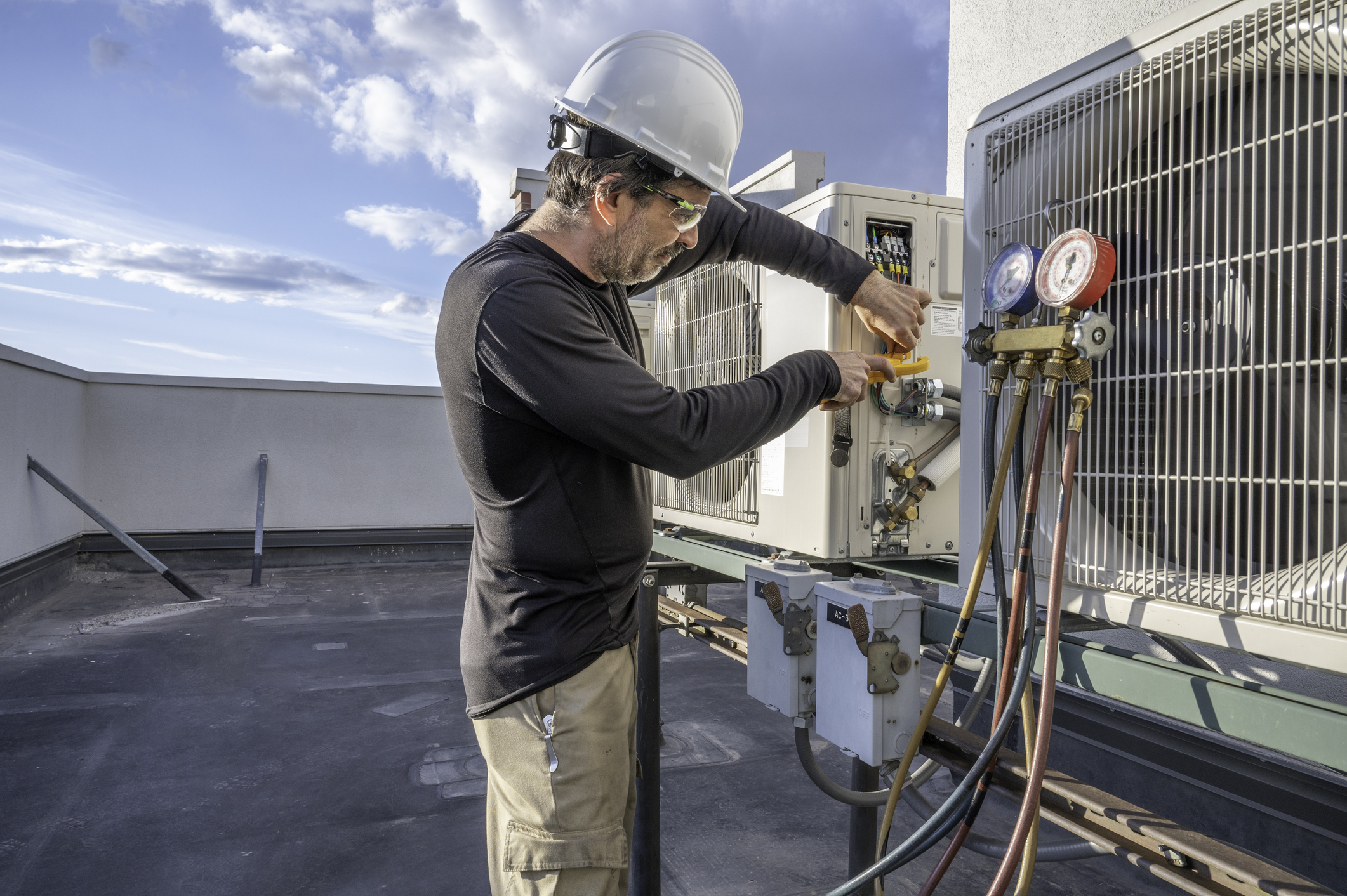 HVAC technician performing a service on a commercial AC unit