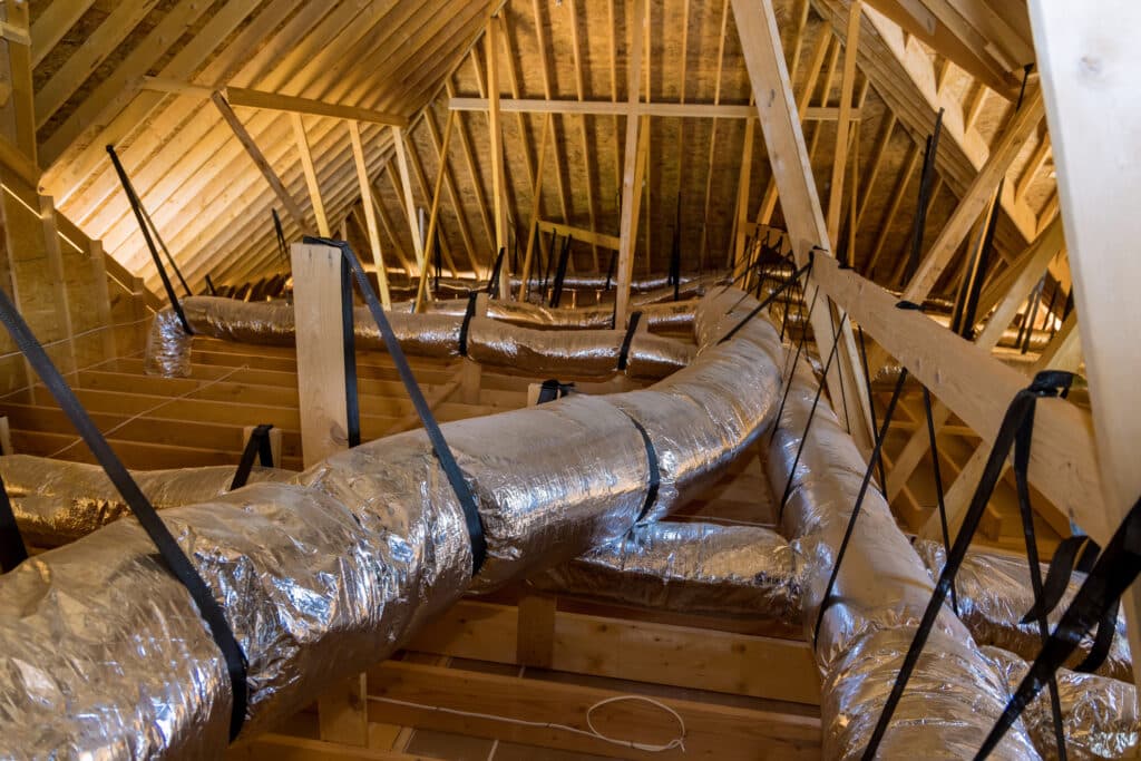 Ventilation pipes on the unfinished ceiling of the attic in a newly constructed home.